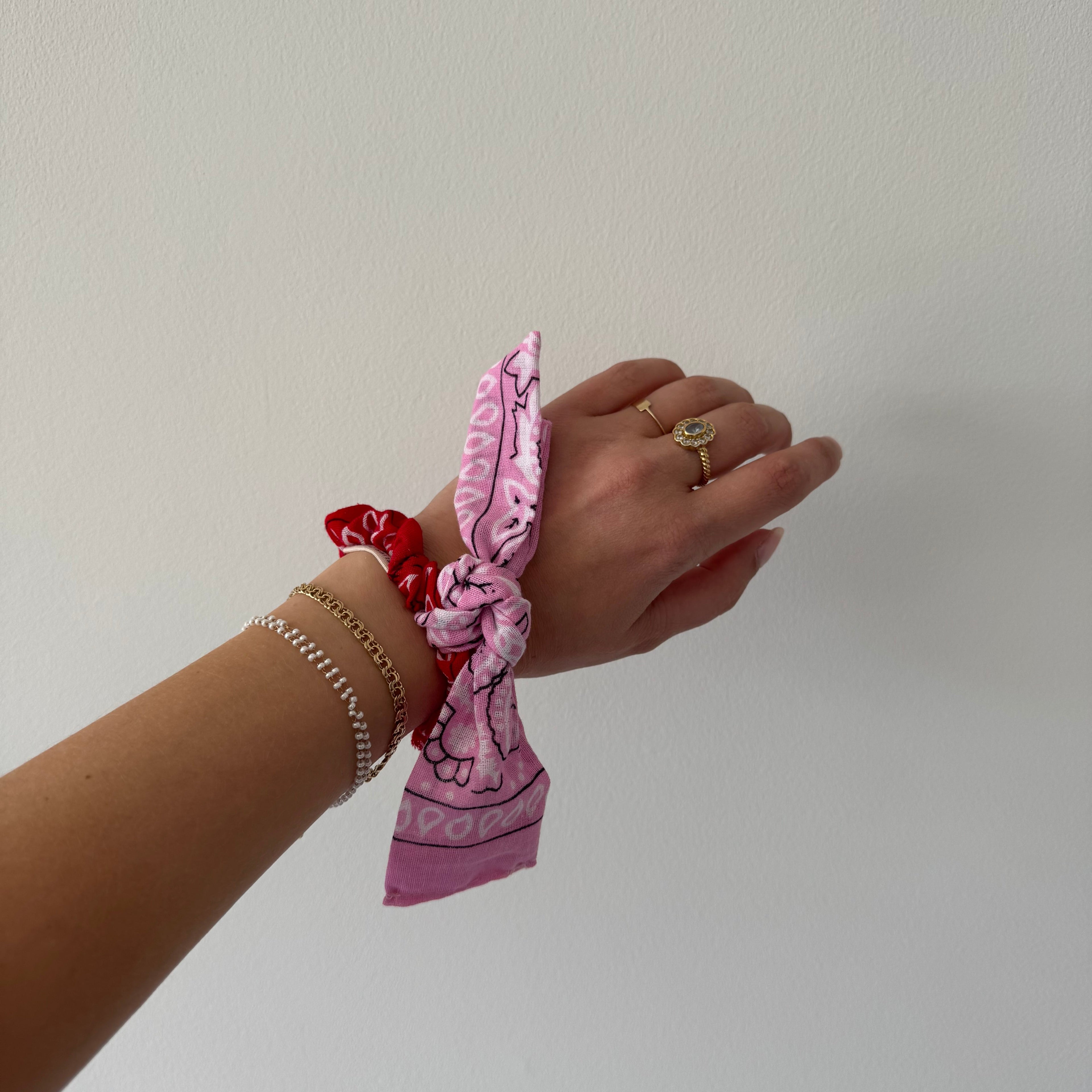 Een rode met roze bandana scrunchie
