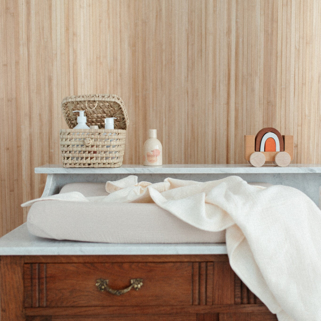 handdoek met capuchon liggend op een commode. met verzorgingsproducten.