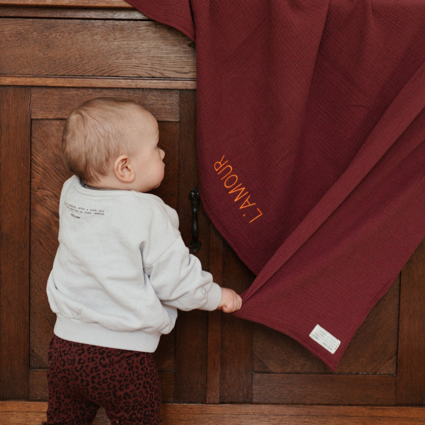 baby pakt laken met tekst van commode.