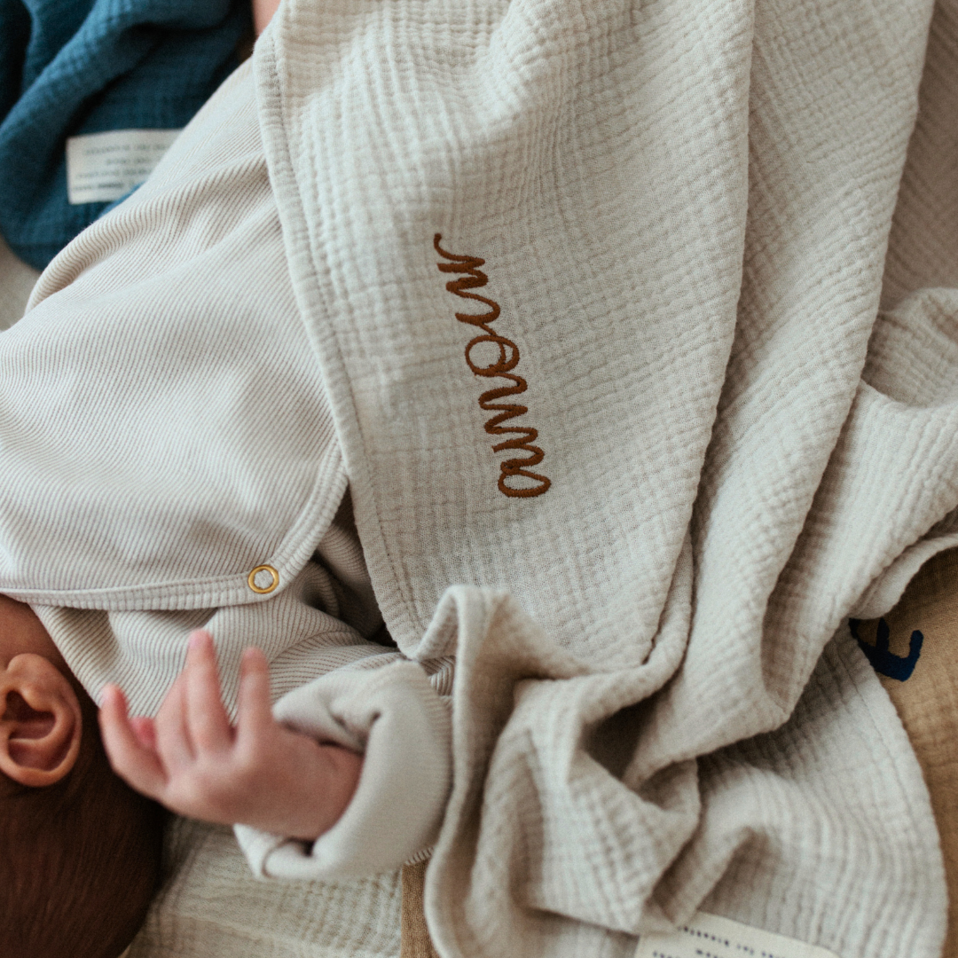 baby ligt onder laken met tekst.