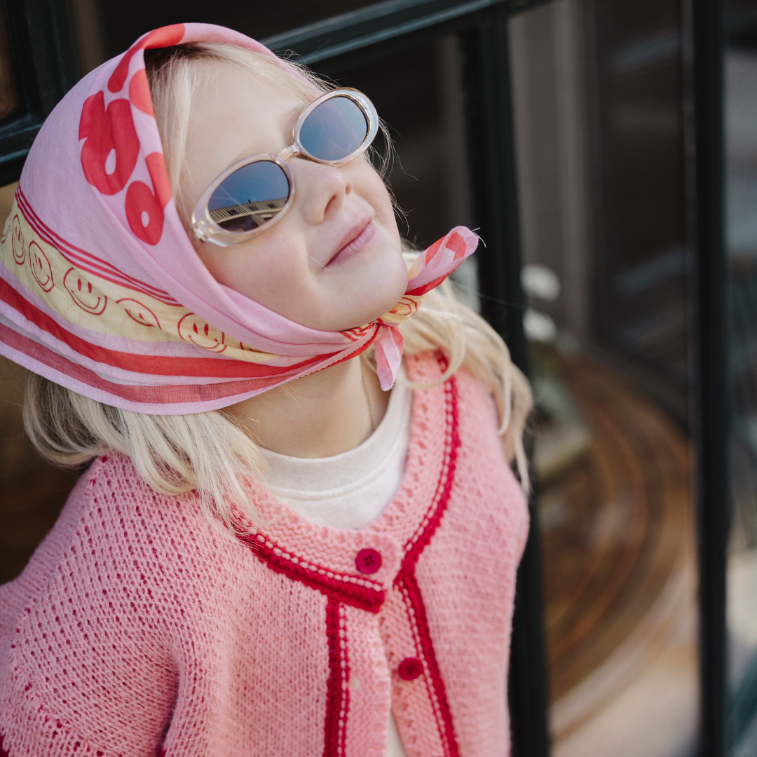 Een roze scarf met een tekst erop