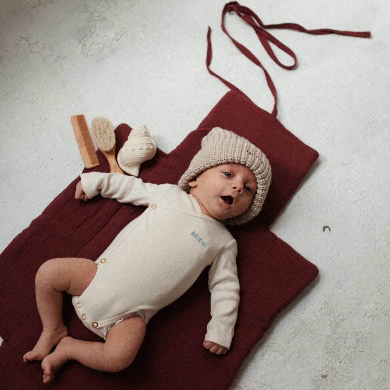 baby ligt op verschoonmat met bijtring.