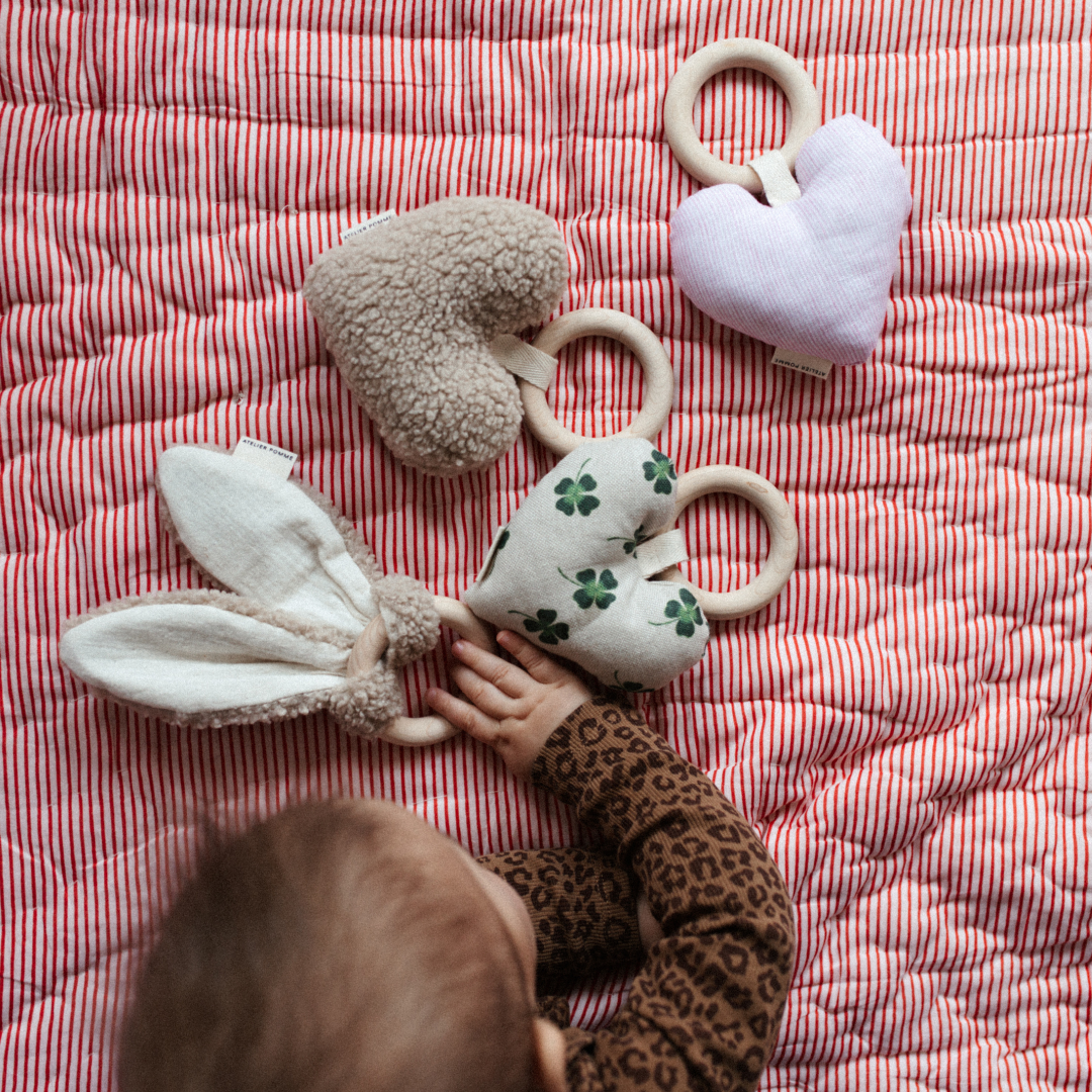 Een roze hart met een bijtring eraan