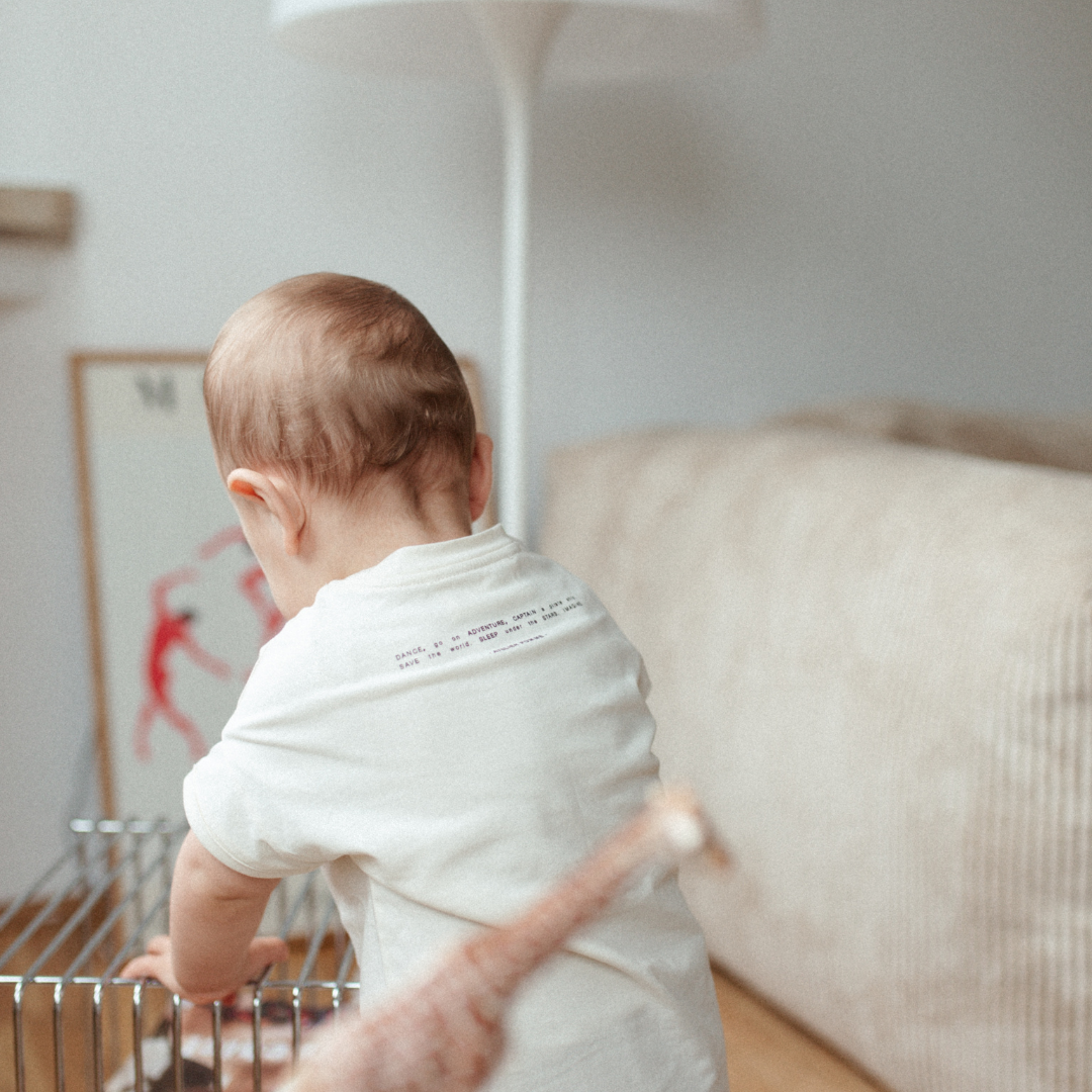 baby draagt witte t-shirt.