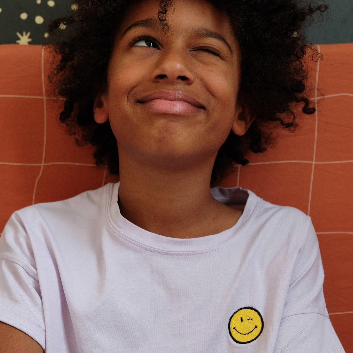 kind draagt lila T-shirt met icoon.