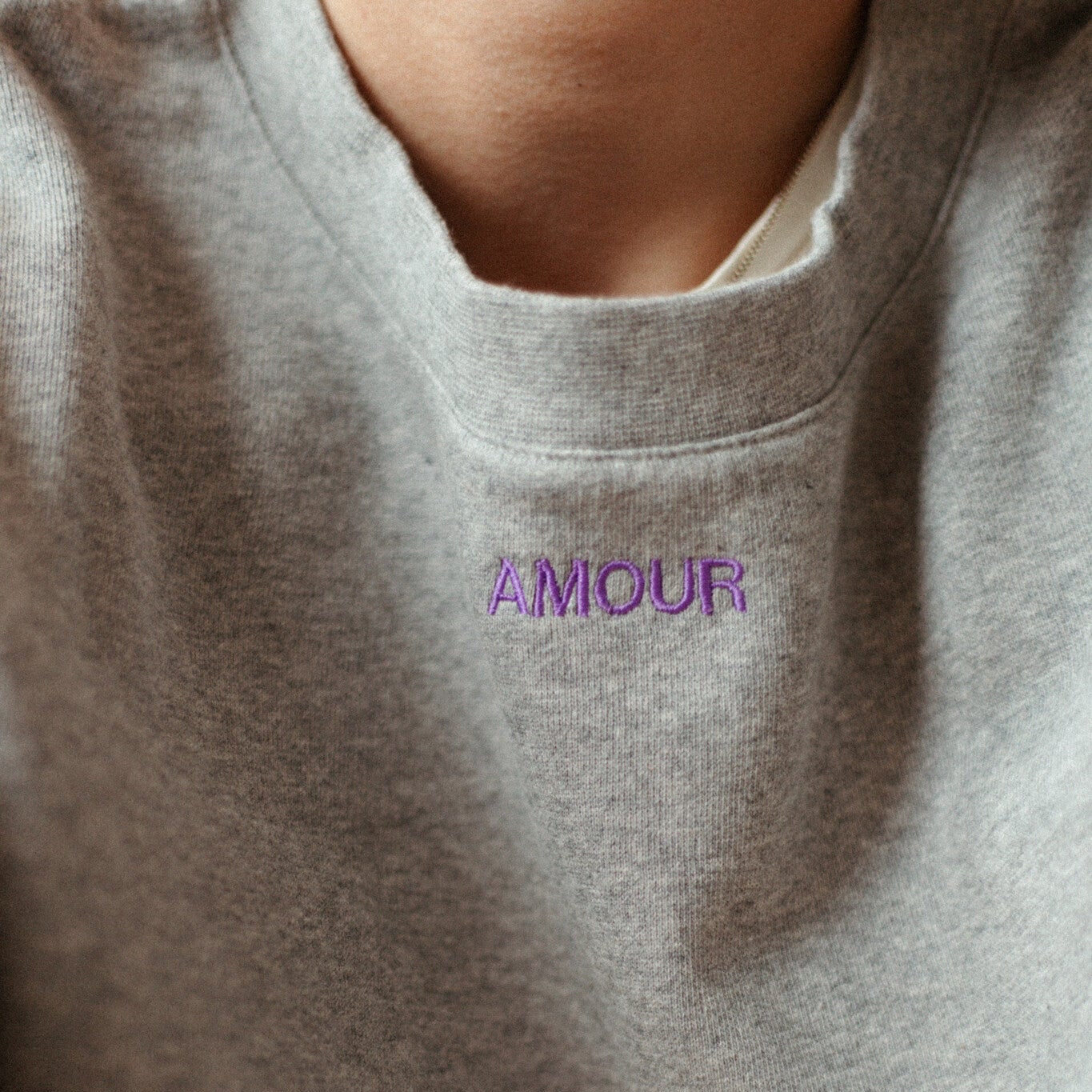Moeder en vrouw in een oversized grijze trui. Gepersonaliseerd met een paarse quote. Gemaakt van 100% biologisch katoen.