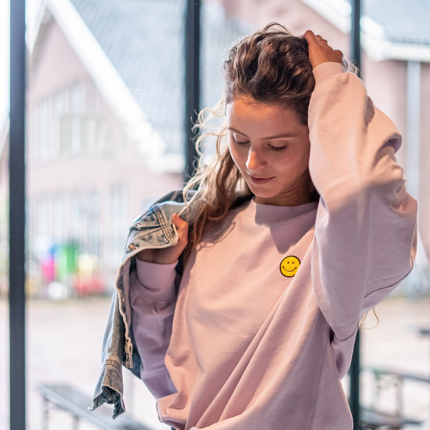 Vrouw in oversized lila trui met smiley gepersonaliseerd.