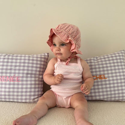 Een geruit, gepersonaliseerd kussen met een naam erop