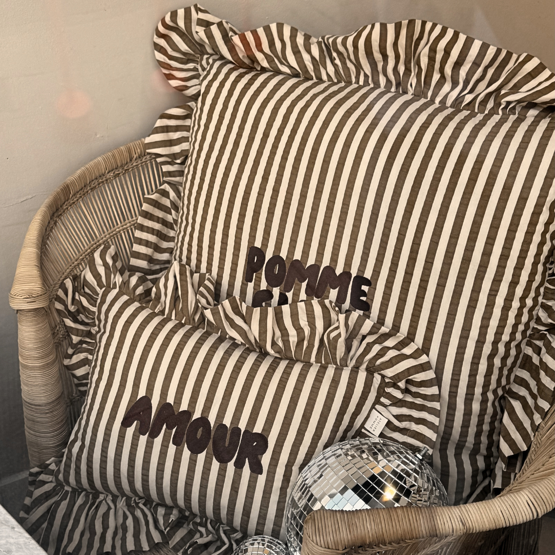 Een gestreept kussen met een gepersonaliseerde tekst erop