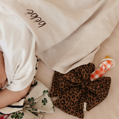 baby ligt onder laken met tekst. speen met speenknuffel. 