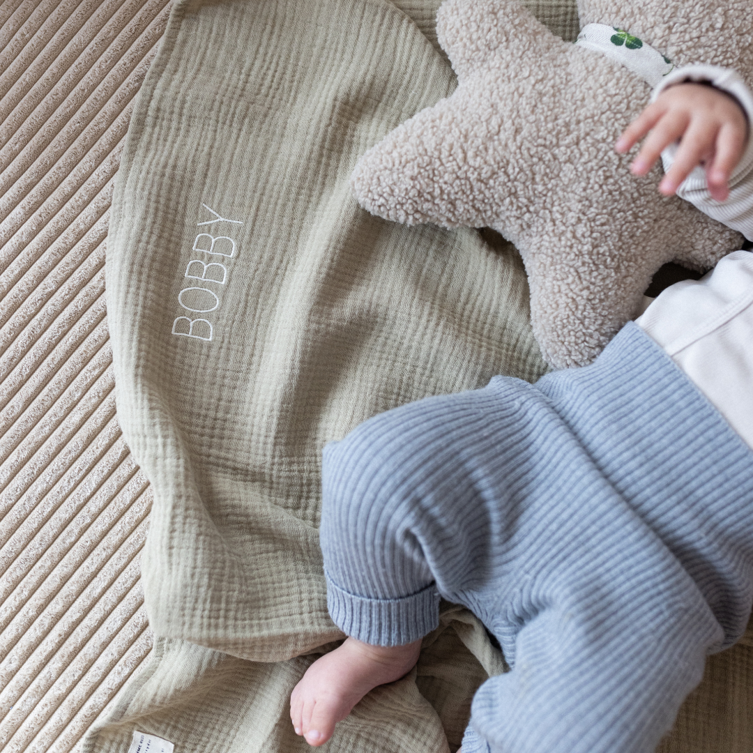 baby ligt op laken 