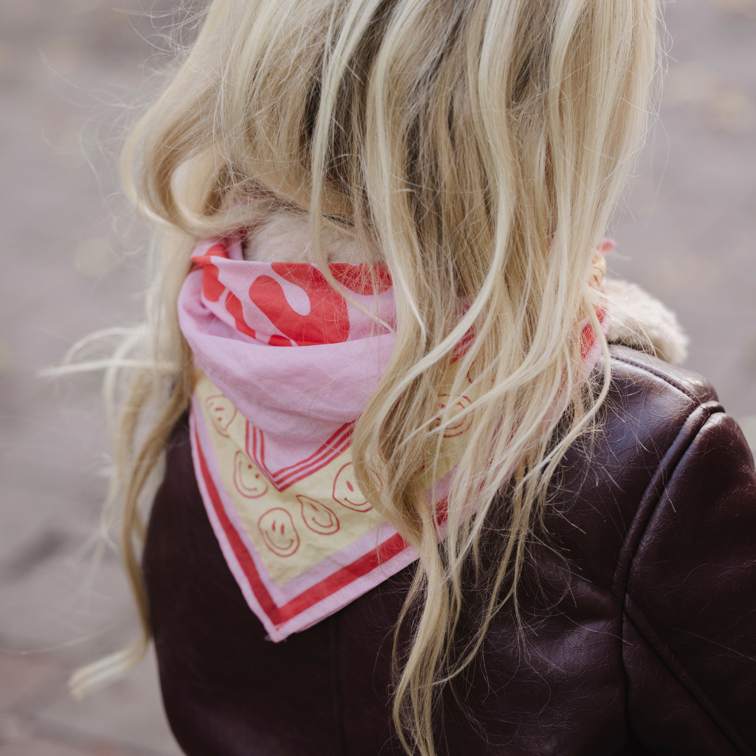Een roze scarf met smiley erop