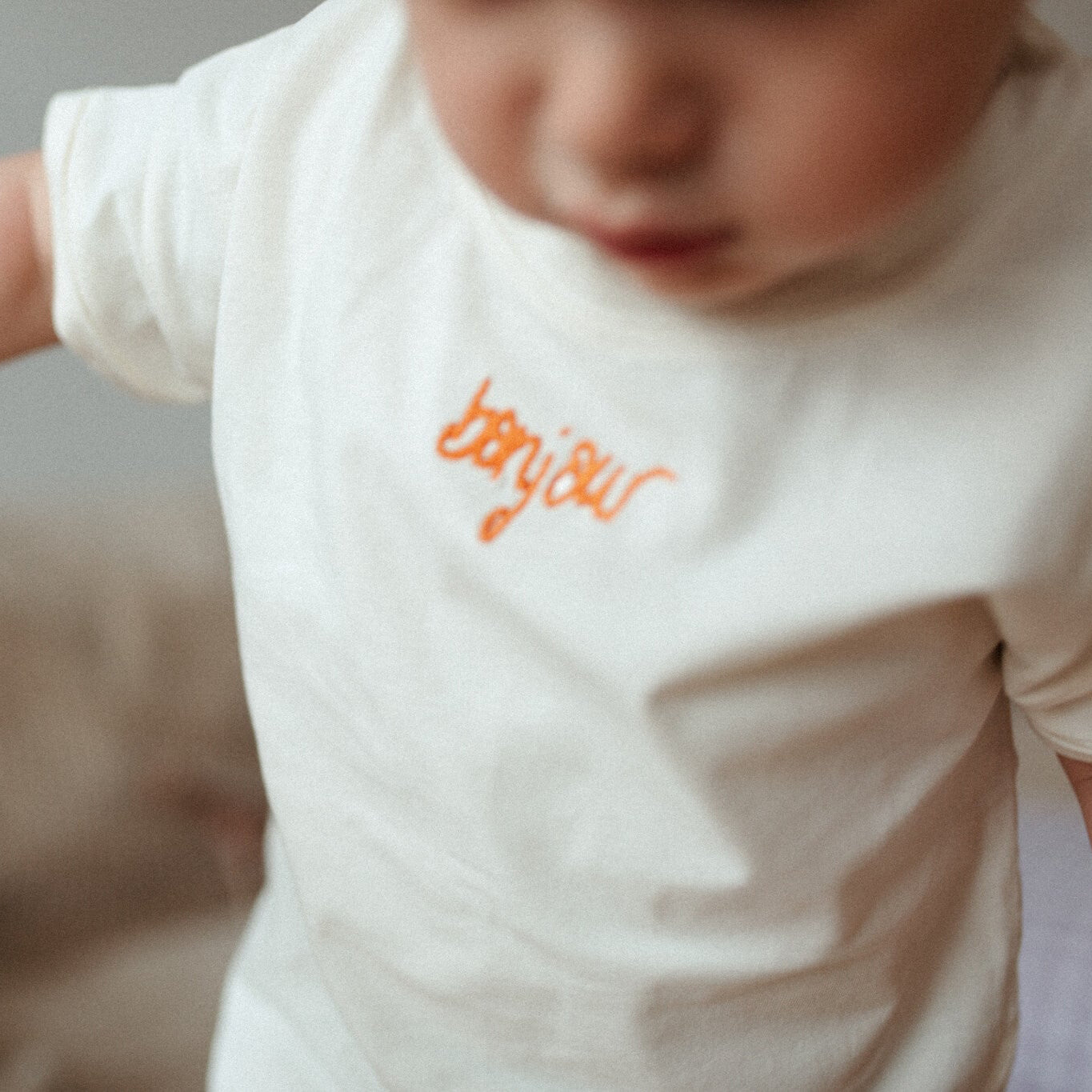 kind draagt wit T-shirt met tekst. 